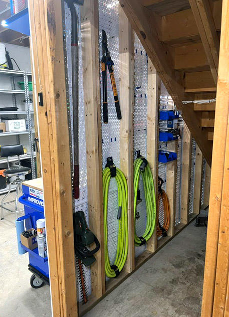 Two Double Sided Pegboards Under Basement Stairs
