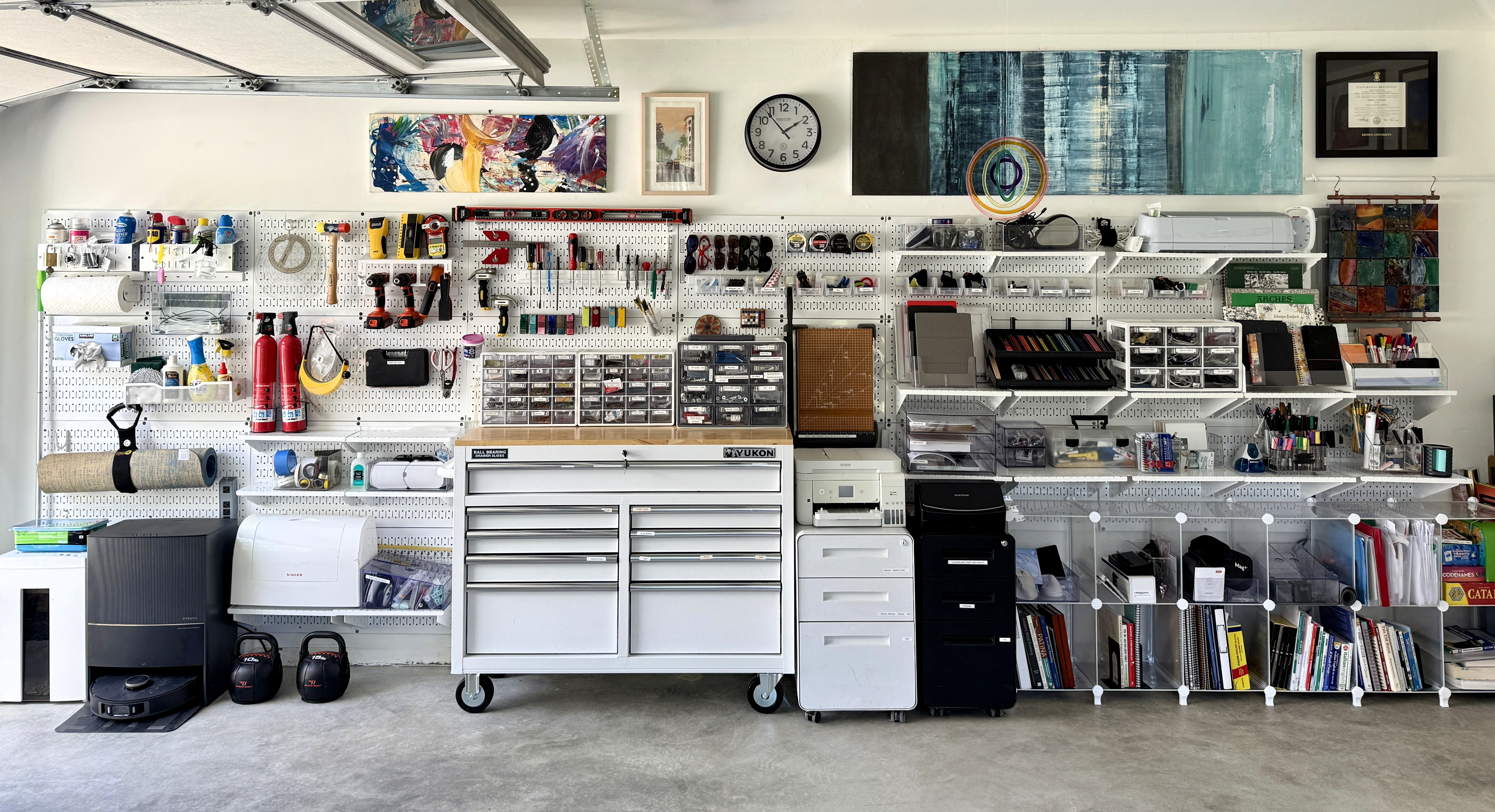 Wall Control metal pegboard garage wall with full workspace organization, tools, storage bins, and modular accessories